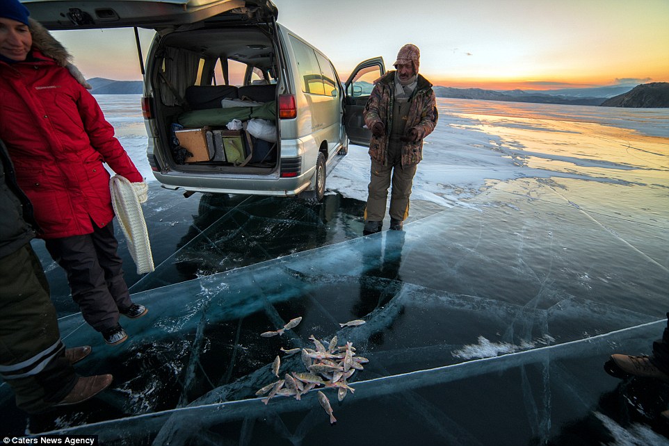Local guides stand around a pile of freshly caught fish during their journey to Olkhon Island at Lake Baikal in Eastern Siberia
